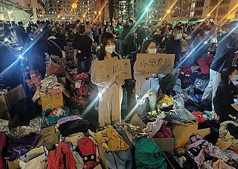 Imagen secundaria 1 - En la primera imagen se apilan jaulas para las mascotas cedidas por los vecinos; en la segunda, voluntarias reparten ropa donada para niño; en la última, una vecina de Tai Po abandona el pueblo cargando con sus pertenencias
